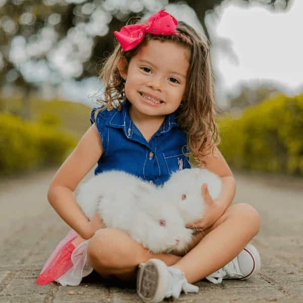 niña con dos conejos 